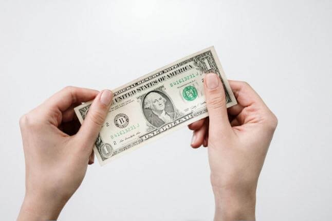 Easy ways to save money picture holding on to dollar bill