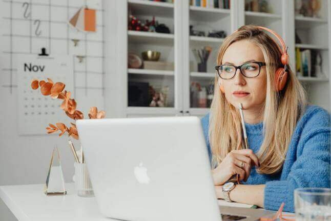 Woman using a laptop while taking notes, representing an investor personality test.